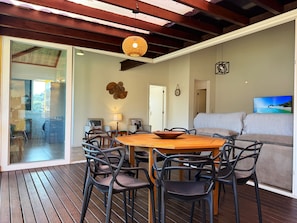Un comedor con mesa y sillas de madera, un sofá y una televisión.