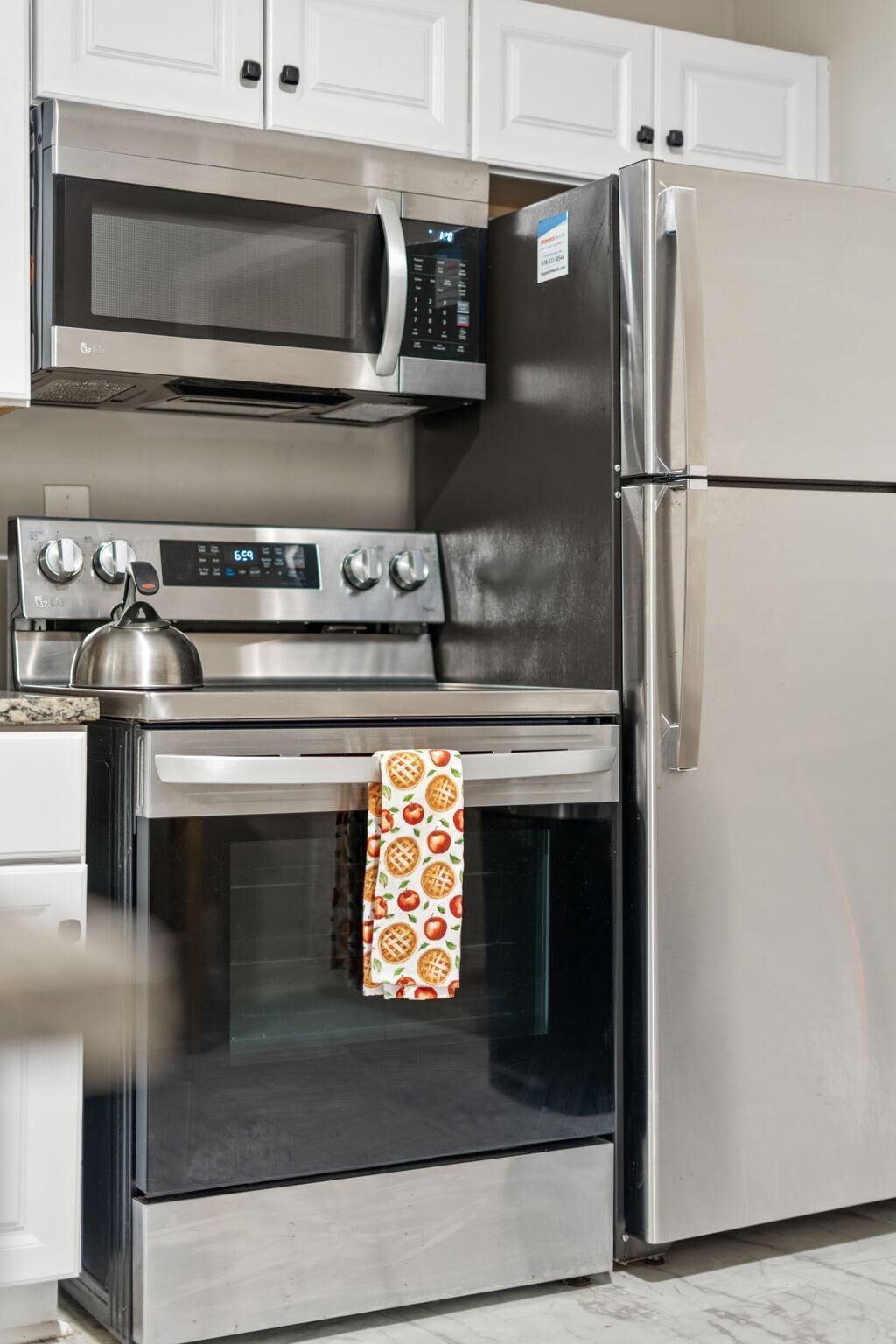 Una cocina con microondas, horno y refrigerador de acero inoxidable.