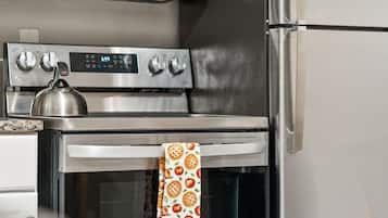 A kitchen with a stainless steel microwave, oven, and refrigerator.