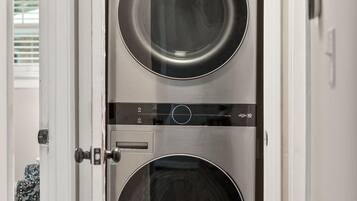 A double-door laundry room with stainless steel appliances.