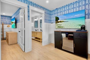 Una habitación con un armario de madera, un televisor en la pared y suelo de madera.