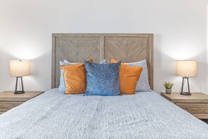 A bed with a patterned bedspread, two side tables with lamps, and a wooden headboard. - 2 Min. Walk to Beach/Ocean Views/Hot Tub/Game Room/Bikes/In-Law Suite (St. Augustine)