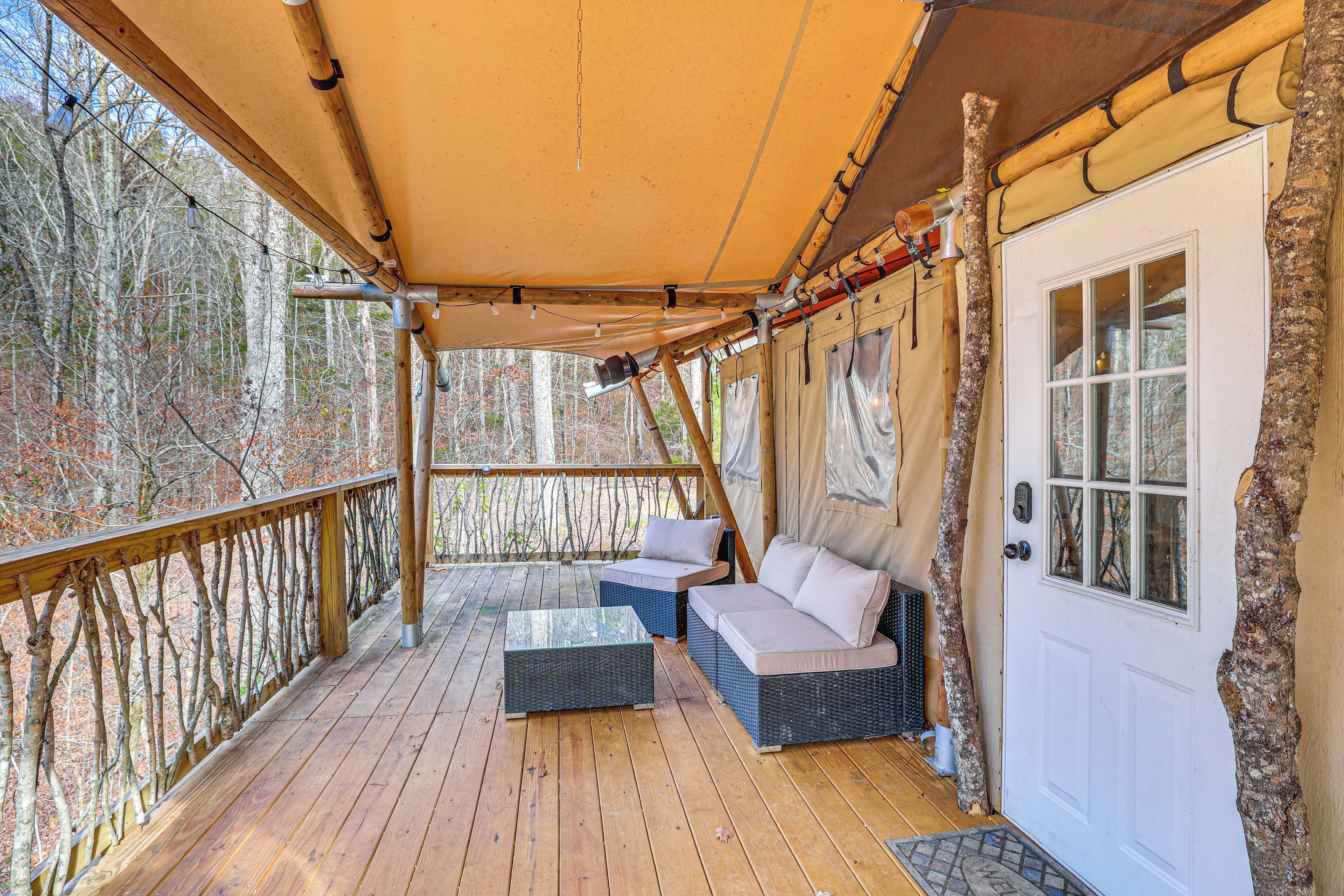 Eine überdachte Terrasse mit Korbmöbeln und einer weißen Tür.
