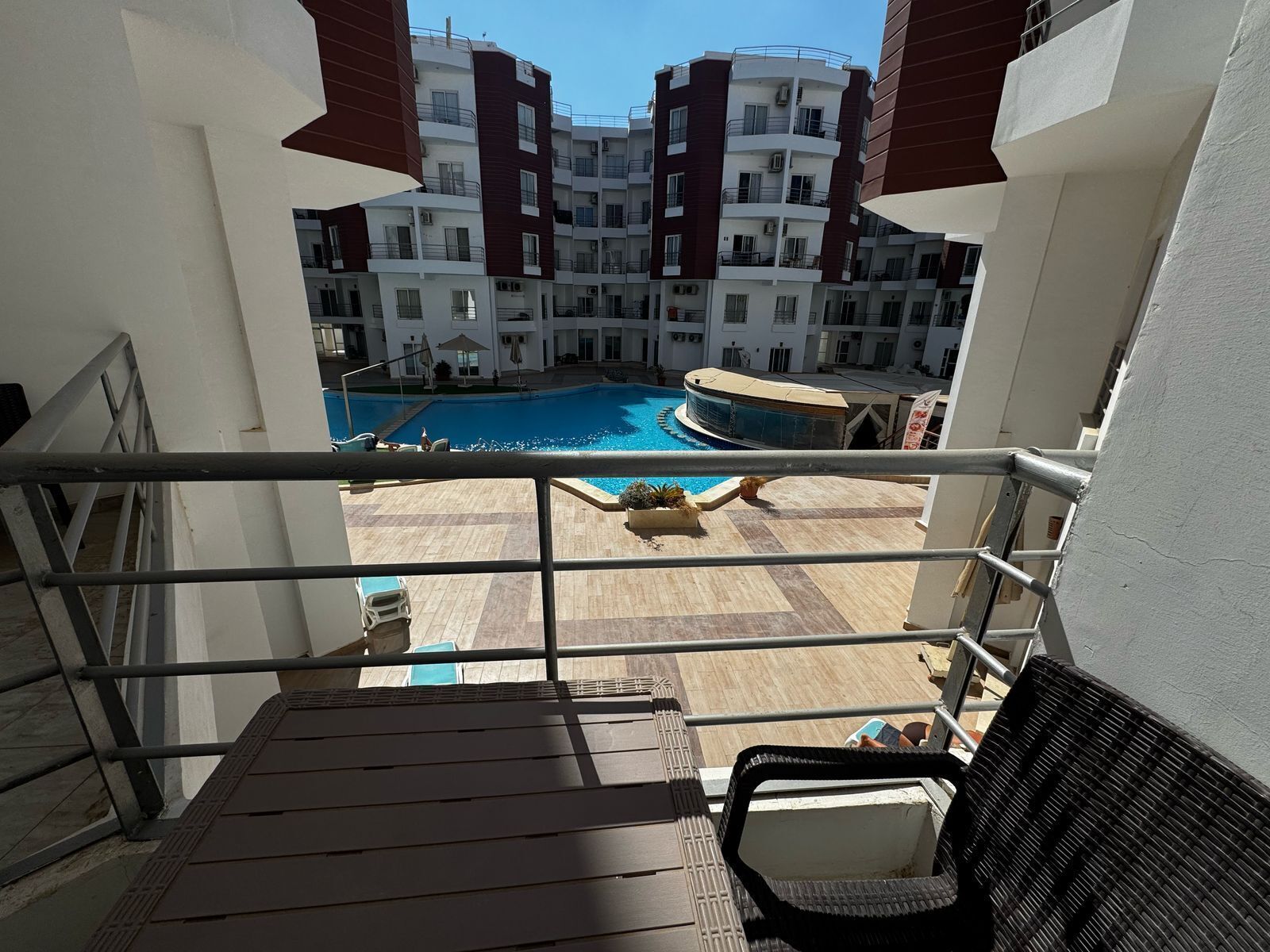 Un espace piscine offrant une vue sur un immeuble à plusieurs étages en arrière-plan.