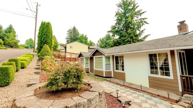 A row of single-story houses with a paved driveway and a well-maintained garden. - 3 Bedroom Art Retreat with Billiards and Art Studio near Portland (Vancouver)