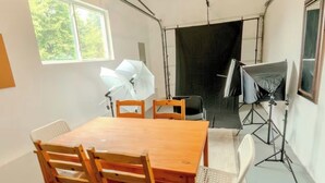 A room with a wooden table and chairs, a window, and photography equipment. - 3 Bedroom Art Retreat with Billiards and Art Studio near Portland (Vancouver)