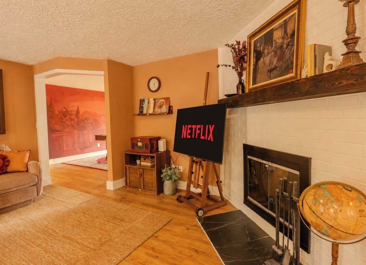 A living room with a fireplace, a television on a stand, and a globe on a stand.
