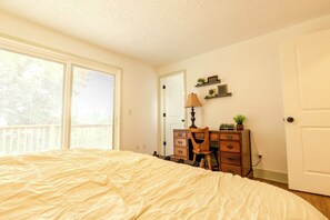 Ein Schlafzimmer mit Bett, Kommode, Schreibtisch und Stuhl.