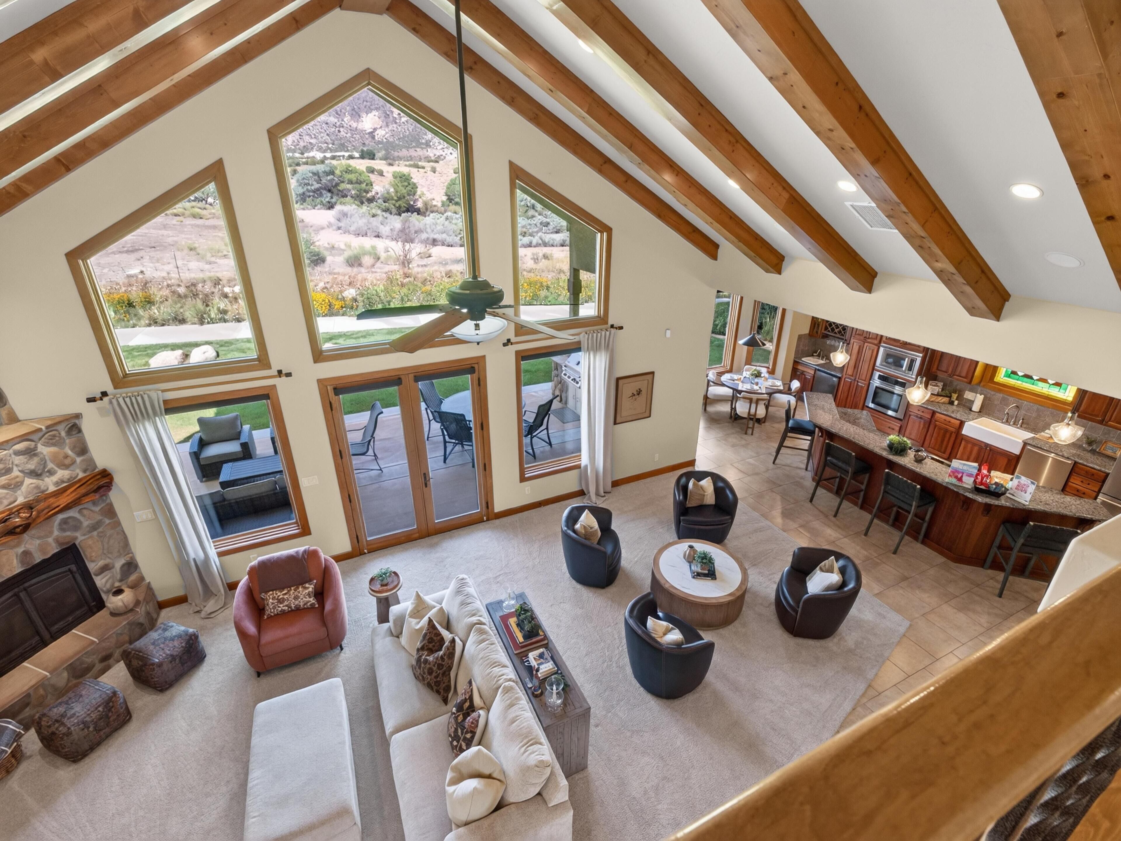 A spacious living area with a fireplace, large windows, and a view of the outdoors.