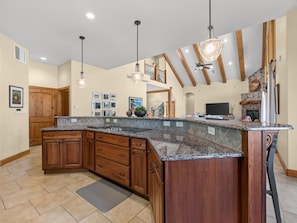 A spacious kitchen with a large island, wooden cabinets, and pendant lighting. - NEW! Grand Vista: Hot Tub & Luxury Views (Grand Junction)