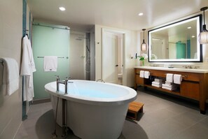 Une salle de bain moderne avec une baignoire sur pieds, une douche à l’italienne et un meuble-lavabo doté d’un grand miroir.