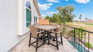 An outdoor patio with a table and chairs, a pool, and a view of a residential area. - Fairway Oasis:  Arrowhead Ranch Fairway Retreat with Private Pool (Glendale)