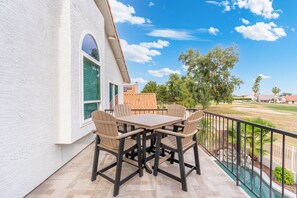 An outdoor patio with a table and chairs, a pool, and a view of a residential area. - Fairway Oasis:  Arrowhead Ranch Fairway Retreat with Private Pool (Glendale)