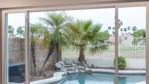 A swimming pool with palm trees and a stone wall. - Fairway Oasis:  Arrowhead Ranch Fairway Retreat with Private Pool (Glendale)