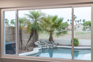 A swimming pool with palm trees and a stone wall. - Fairway Oasis:  Arrowhead Ranch Fairway Retreat with Private Pool (Glendale)
