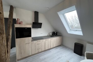 Eine moderne Küche mit Backofen, Mikrowelle und Kaffeemaschine.