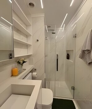 A modern bathroom with a glass shower enclosure, a white sink, and a large mirror. - VN Oscar Freire (São Paulo)