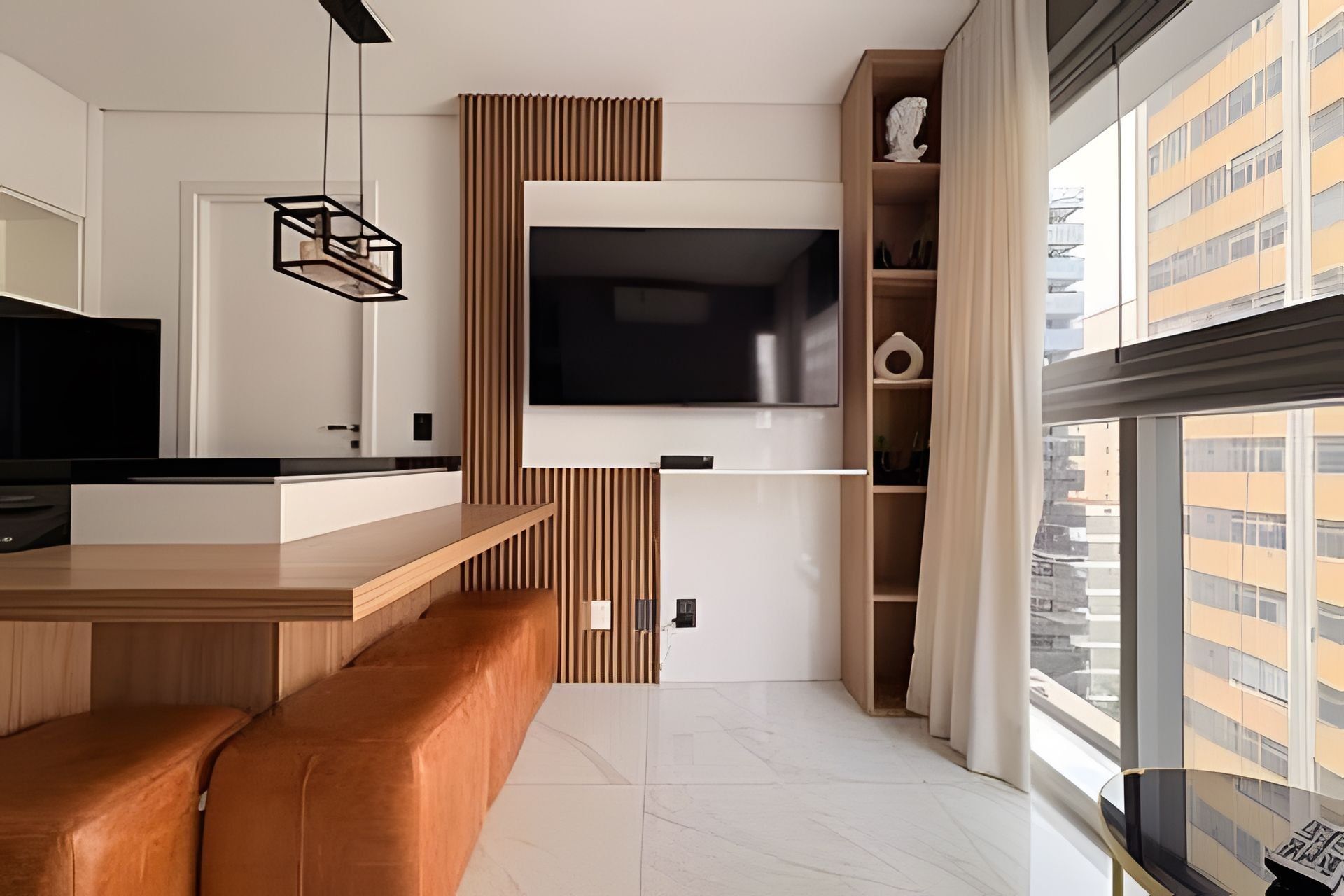 A modern kitchen with a built-in TV, wooden bar counter, and a large window with a city view.