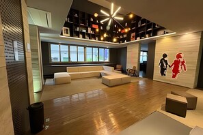 Un interior moderno con un amplio espacio de estar, un techo alto con una lámpara única y un ventanal que aporta luz natural.
