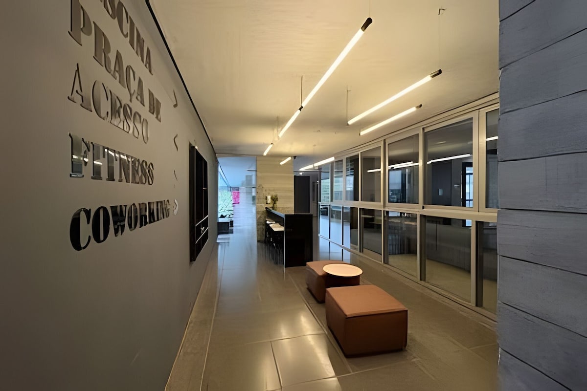 A modern office space with a long corridor, cubicles, and a reception area.