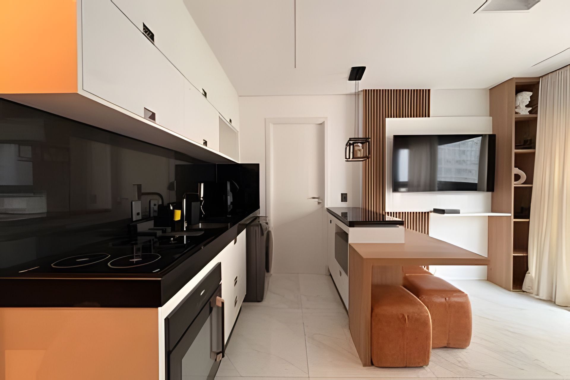 A modern kitchen with a black stove, white cabinets, and a wooden dining table with two cushioned benches.