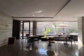 A modern interior with a dining area, large windows, and a view of the outdoors. - VN Oscar Freire (São Paulo)