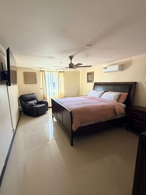A bedroom with a bed, a reclining chair, a ceiling fan, and an air conditioning unit. - Casa renovada,espaciosa y segura con lavadora y secadora. Facturamos (Heroica Ciudad de Cananea)