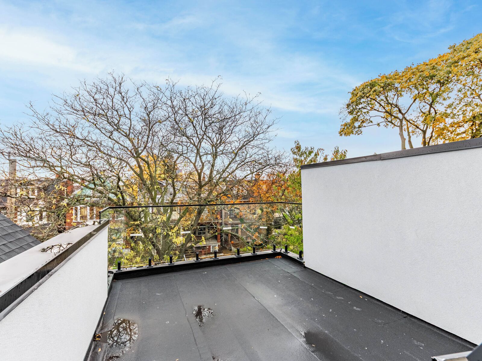 A rooftop terrace with a clear view of trees and buildings.