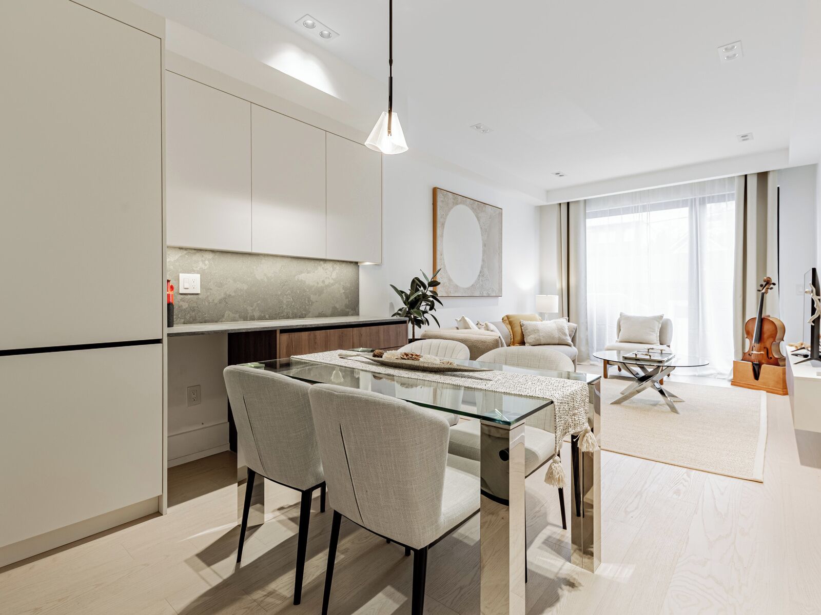 A modern living space with a dining area, kitchen, and seating area.