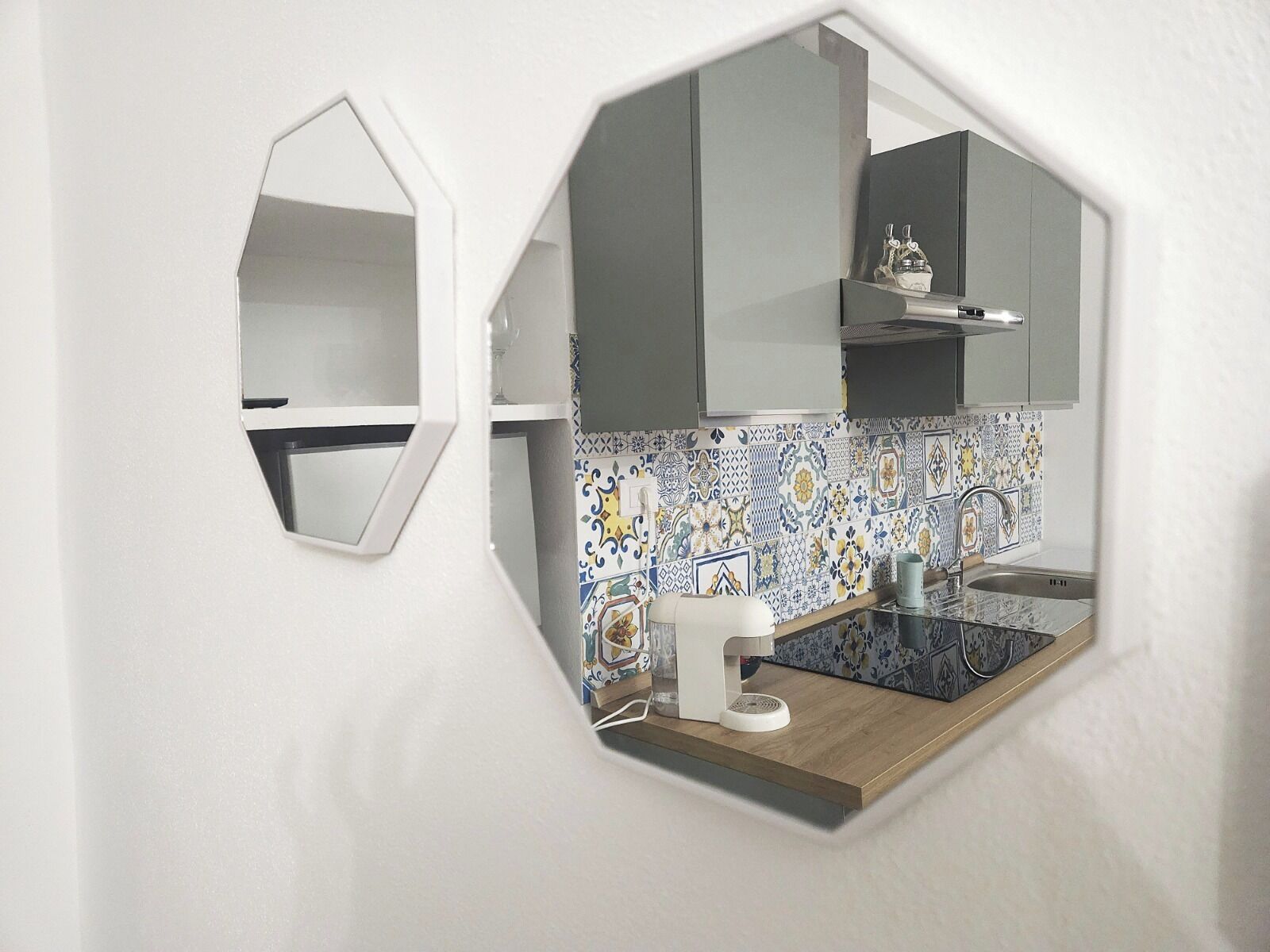 A kitchen with a hexagonal window, a tiled backsplash, and a wooden countertop.
