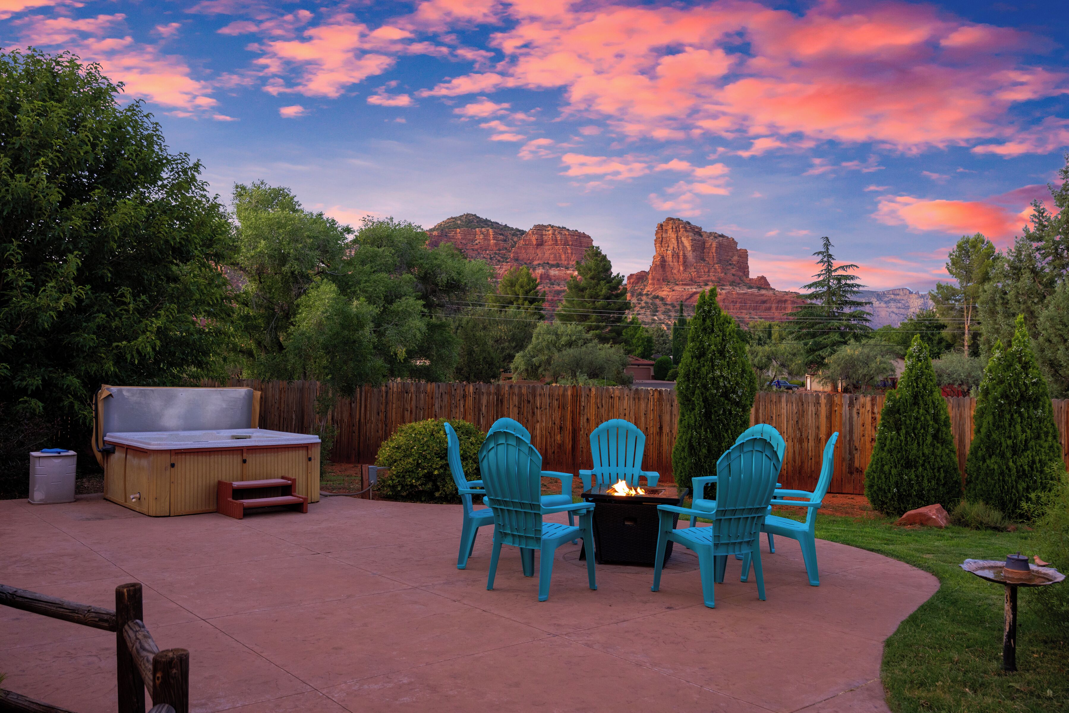 Un patio al aire libre con un brasero, sillas y un jacuzzi.