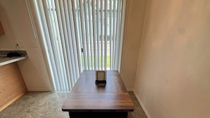 A room with a wooden table, a bench, and a window with blinds. - Quiet Home Near Everything (Hermiston)