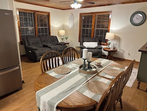 A dining area with a wooden table, chairs, and a chandelier.