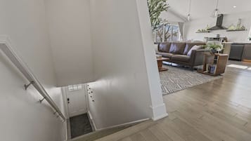 Una sala de estar moderna con un sofá, una mesa de centro y una cocina al fondo.