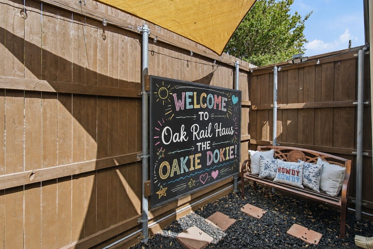 Een houten hek met een bord waarop 'Oak Rail Haus' staat.