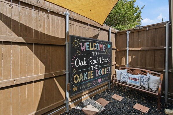 A wooden fence with a welcome sign for Oak Rail Haus.