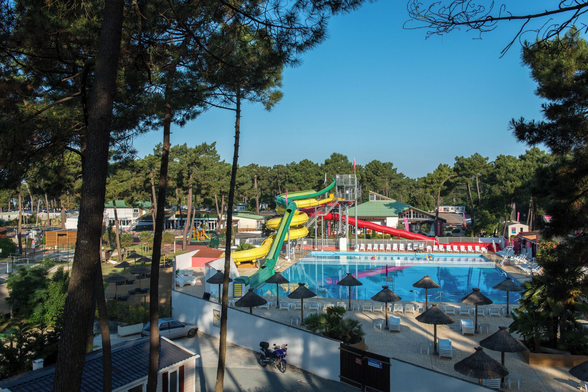 Un parc aquatique doté d’une grande piscine, de toboggans et d’un espace de stationnement.