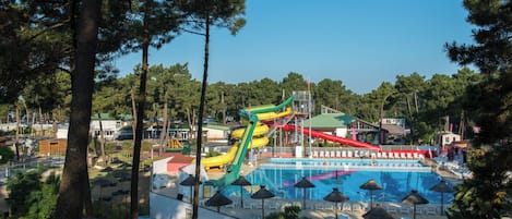 A water park with a large pool, slides, and a parking area.