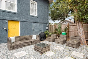 Ein Patio-Bereich mit Sitzgelegenheit und einer gelben Tür.