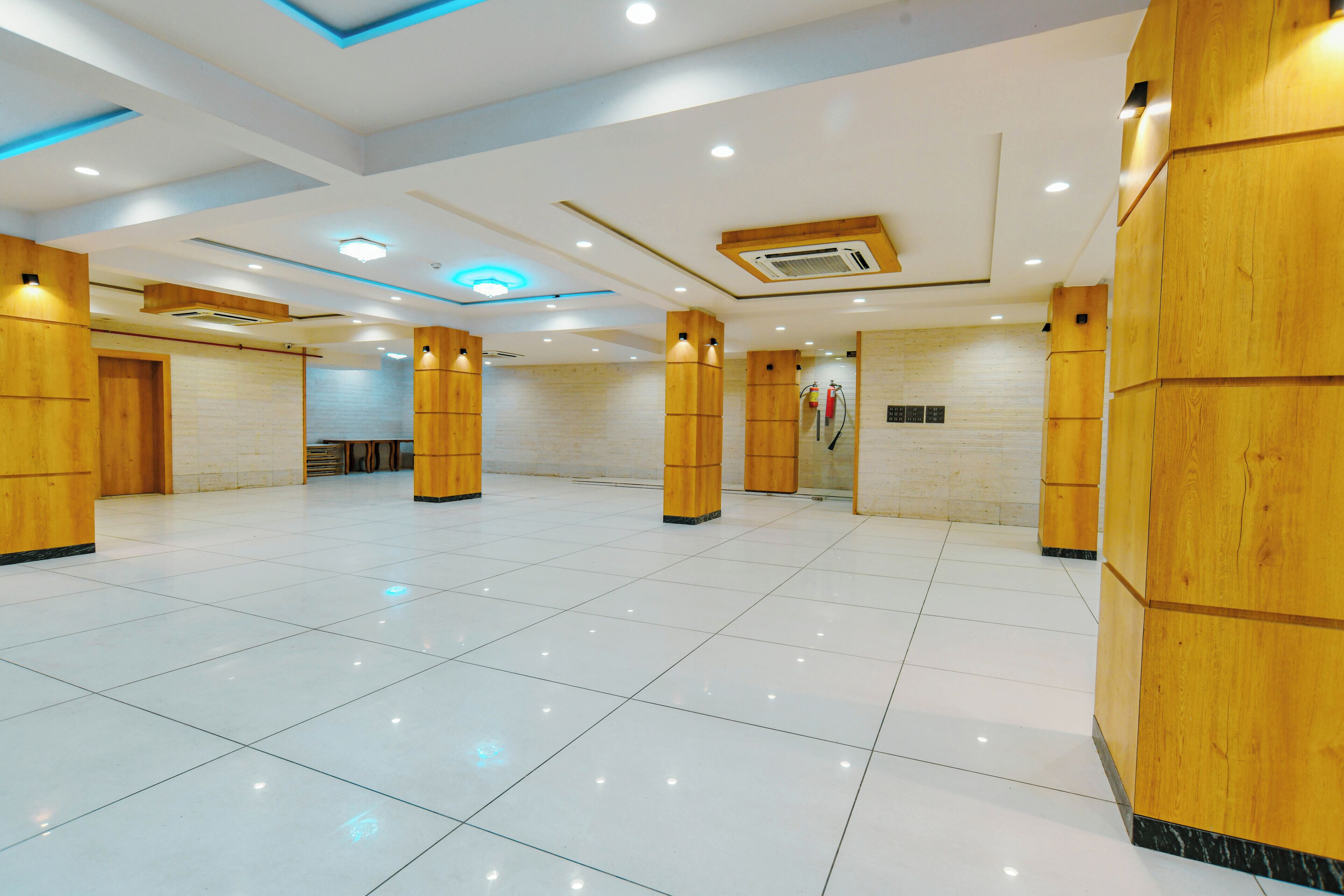 Eine geräumige Lobby mit hoher Decke, eingelassener Beleuchtung und einem glänzenden Fliesenboden.