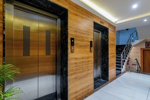 A modern elevator with a wooden panel design and a digital display.