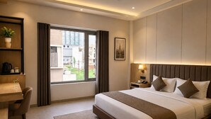 Una habitación de hotel con cama, mesita de noche, lámpara y escritorio con silla.