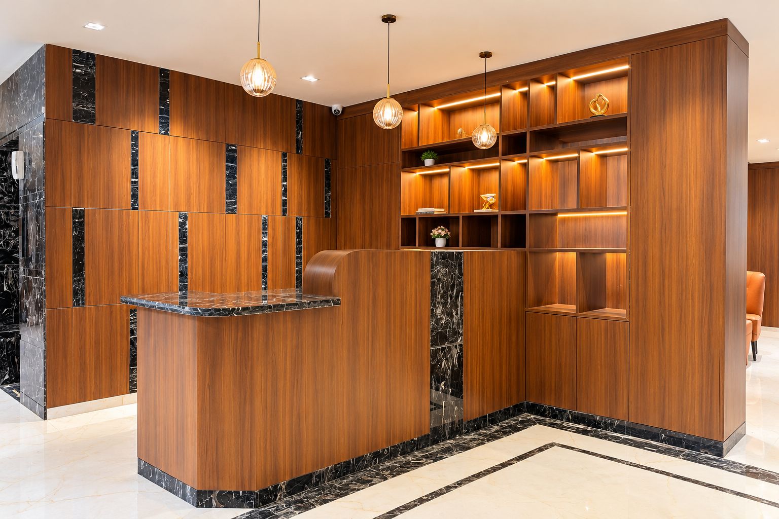 Una zona de recepción con mostrador de mármol, paneles de madera e iluminación colgante.