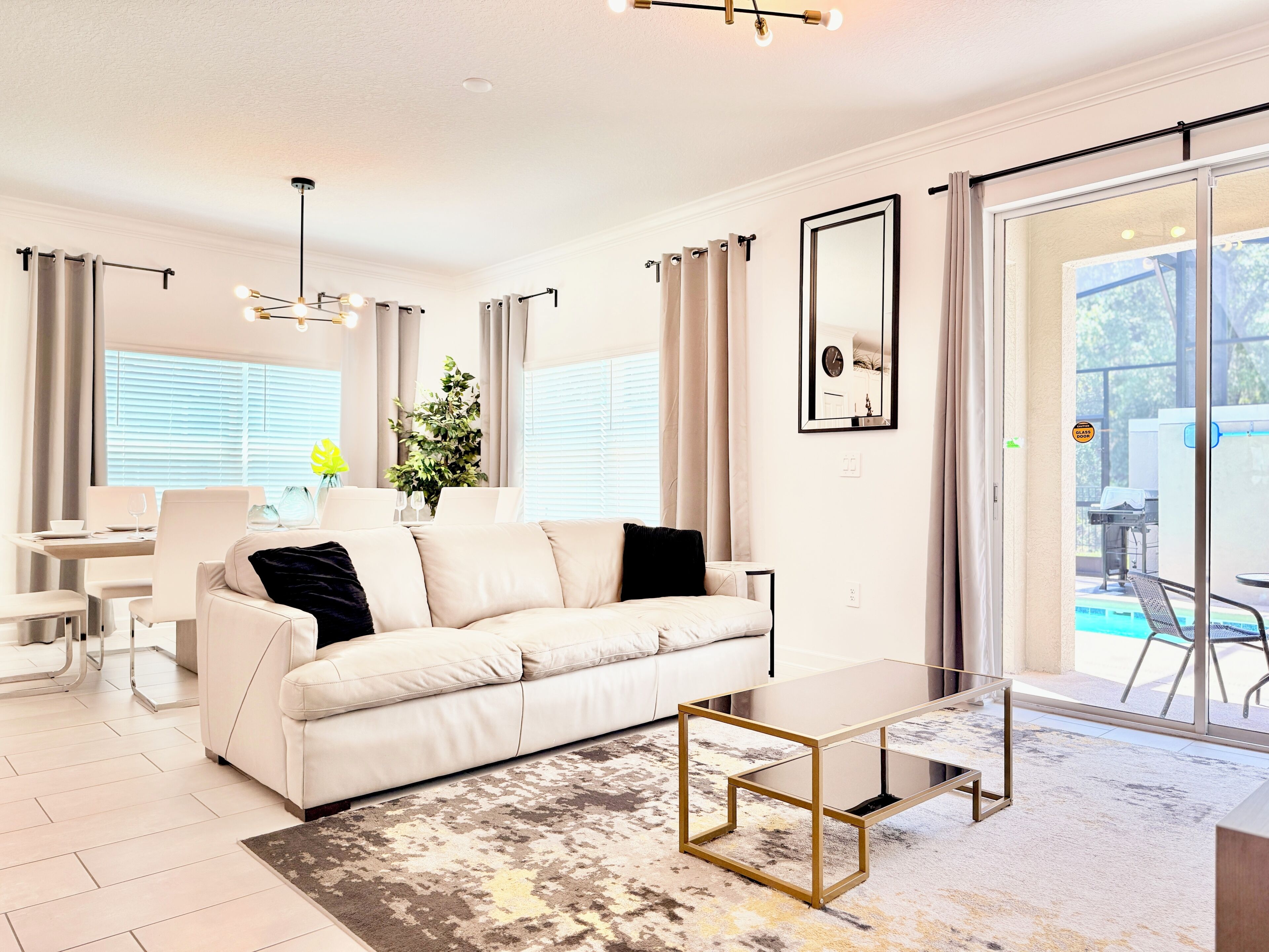 A modern living room with a sofa, coffee table, and dining area.