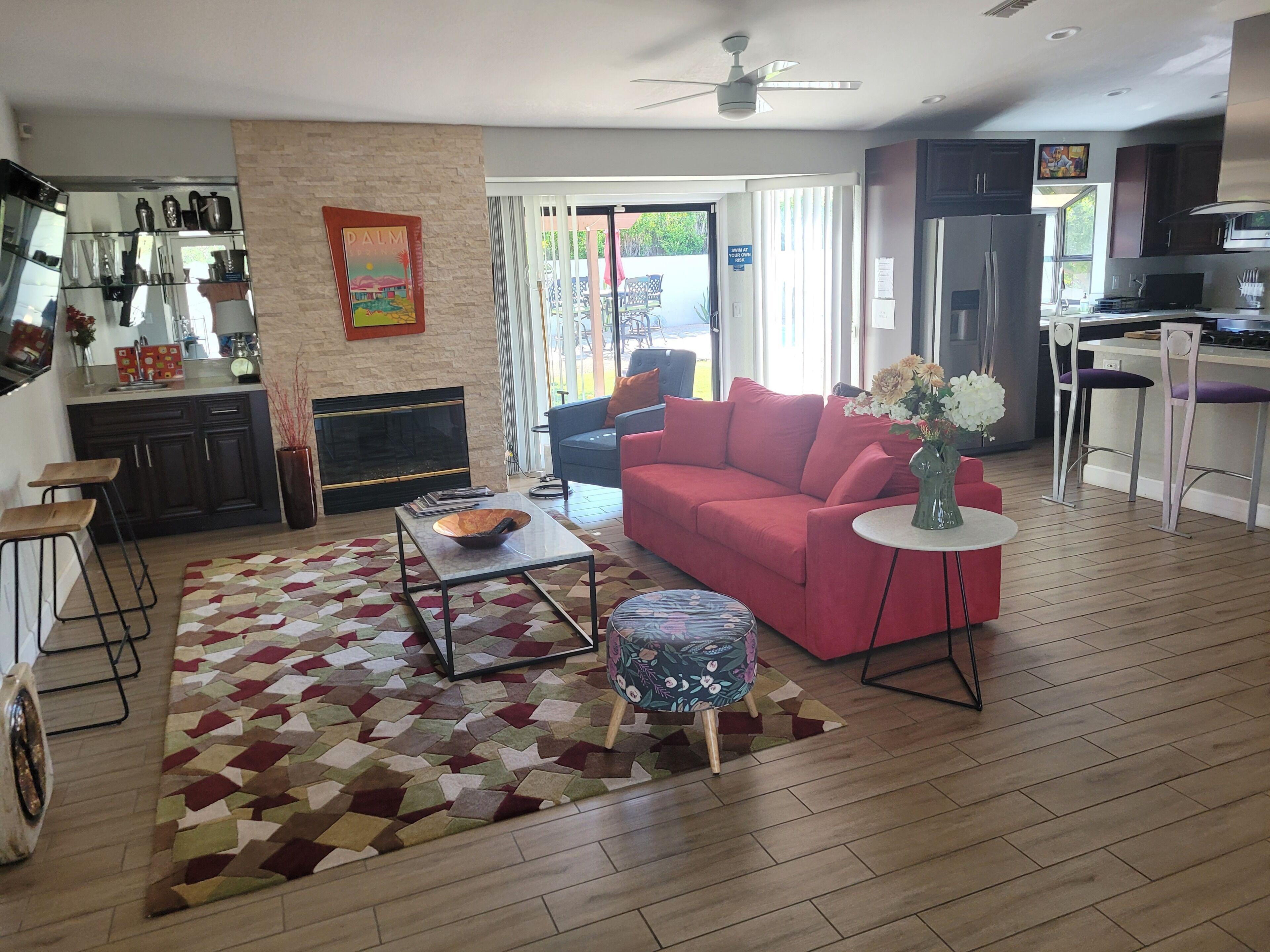 Un salon moderne avec un canapé rouge, une table basse et un tapis à motifs.
