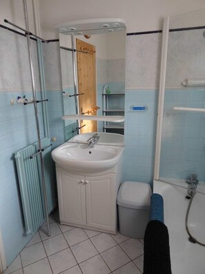 A bathroom with a white sink, mirror, and shower. - 100m from ski slopes, 1st floor, balcony, parking, tv, ski locker, 28m², Valloire (Valloire)