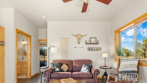 Un salon spacieux avec un canapé en cuir, une table basse et une vue sur l’extérieur.