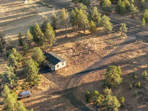 Une propriété rurale comprenant une seule maison, un chemin de terre et un véhicule garé.