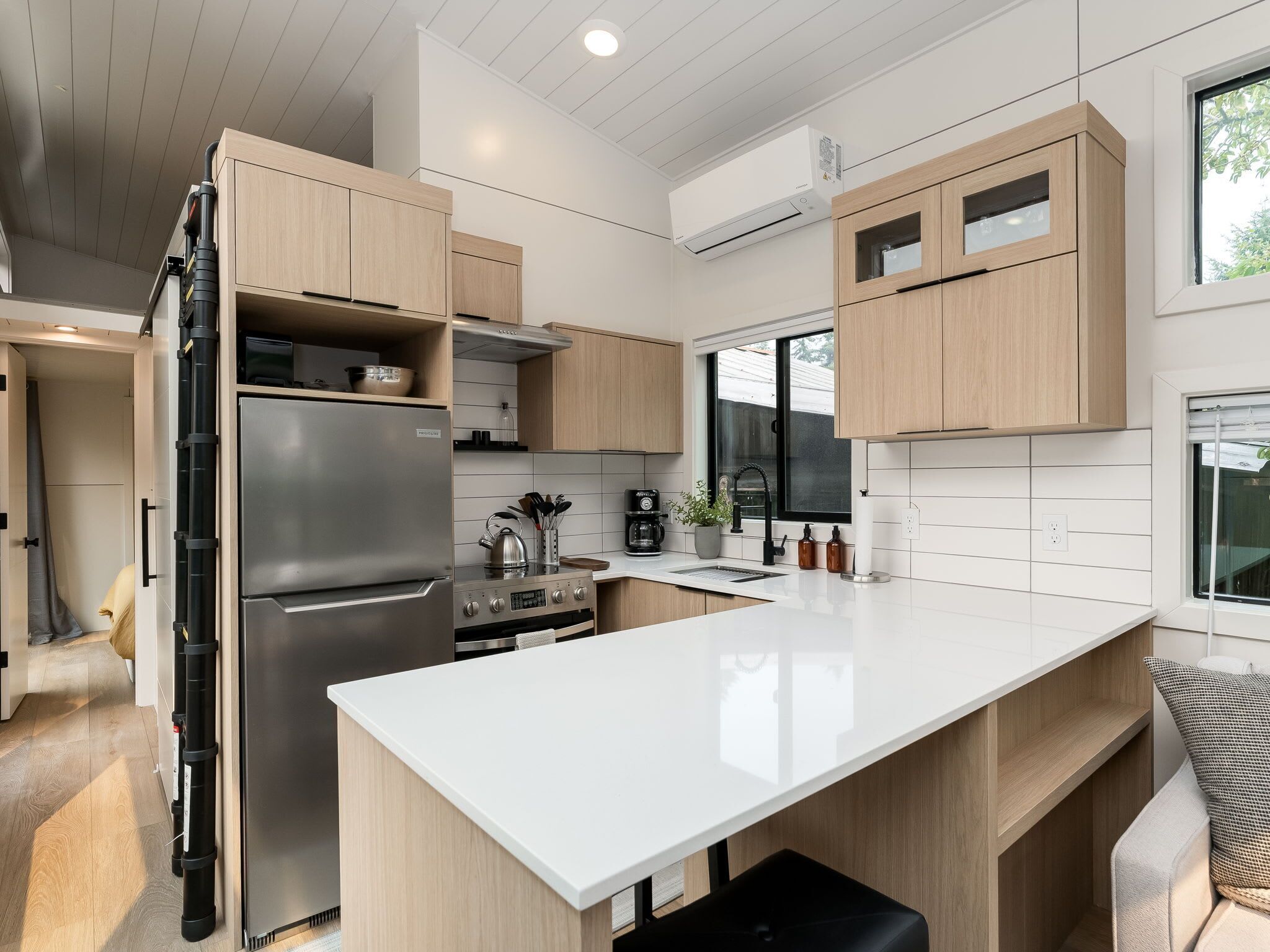 Cocina moderna con una isla grande, electrodomésticos de acero inoxidable y armarios de madera.