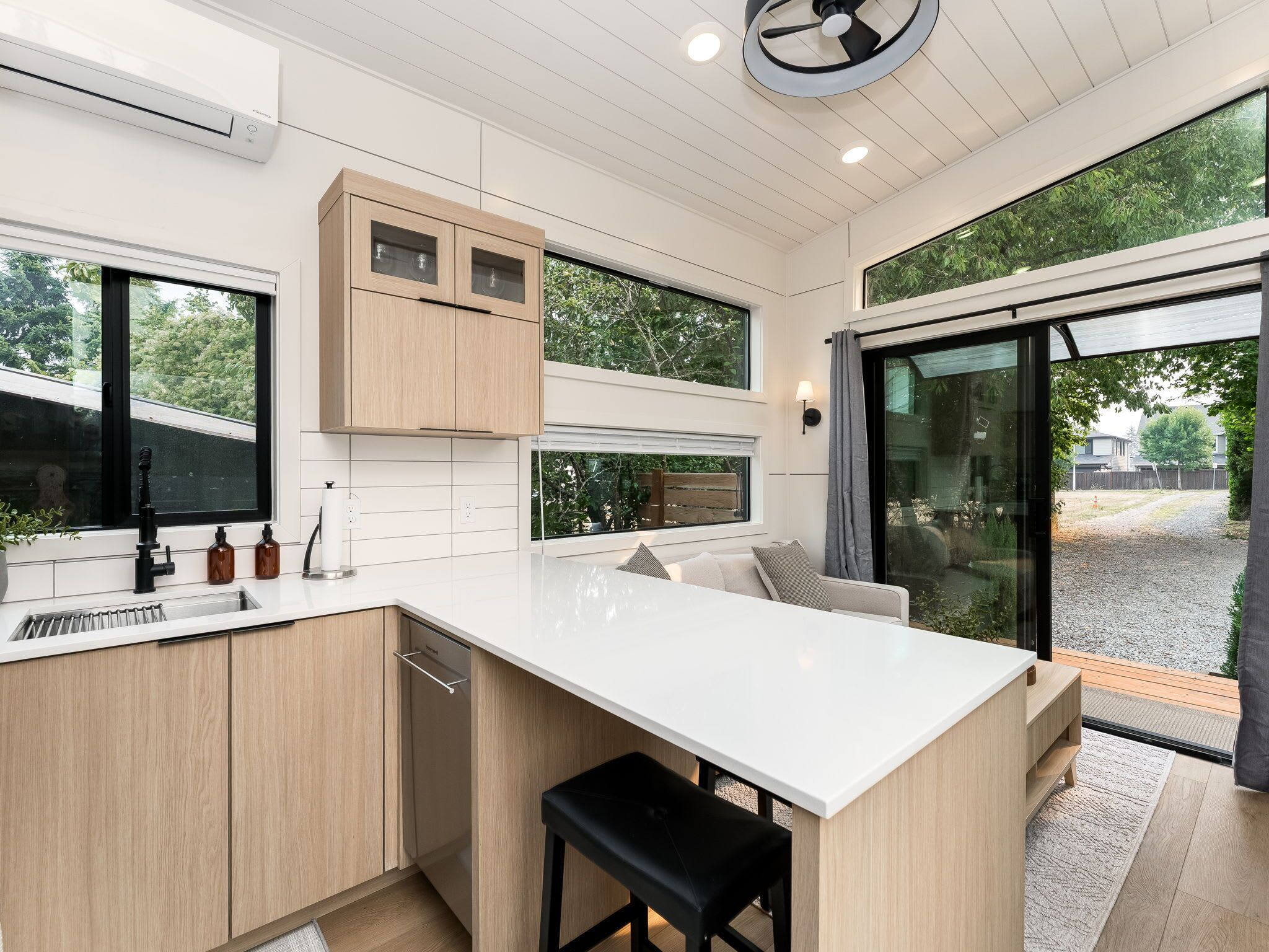 Una cocina moderna con una isla grande, armarios de madera y vistas al exterior.